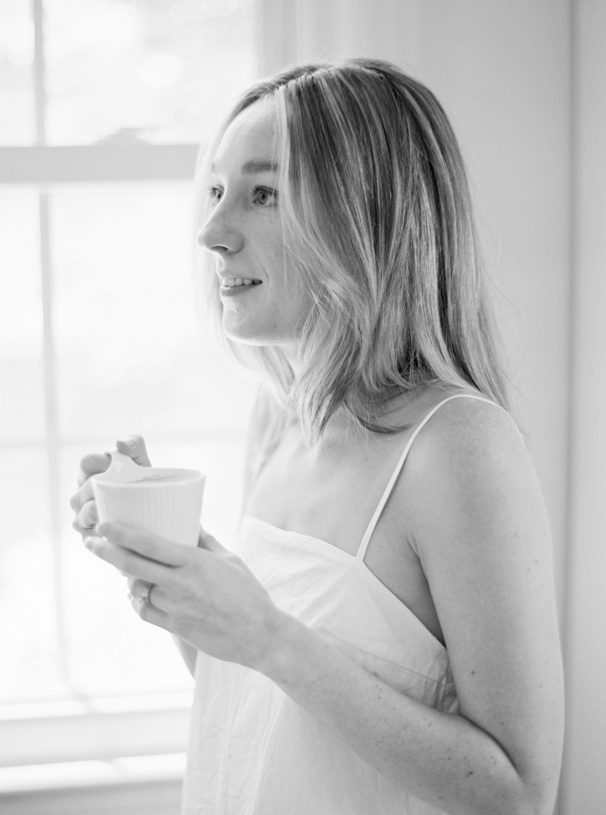 Lifestyle in-home session in Nashville. Portrait of wife holding cup of coffee in black and white.