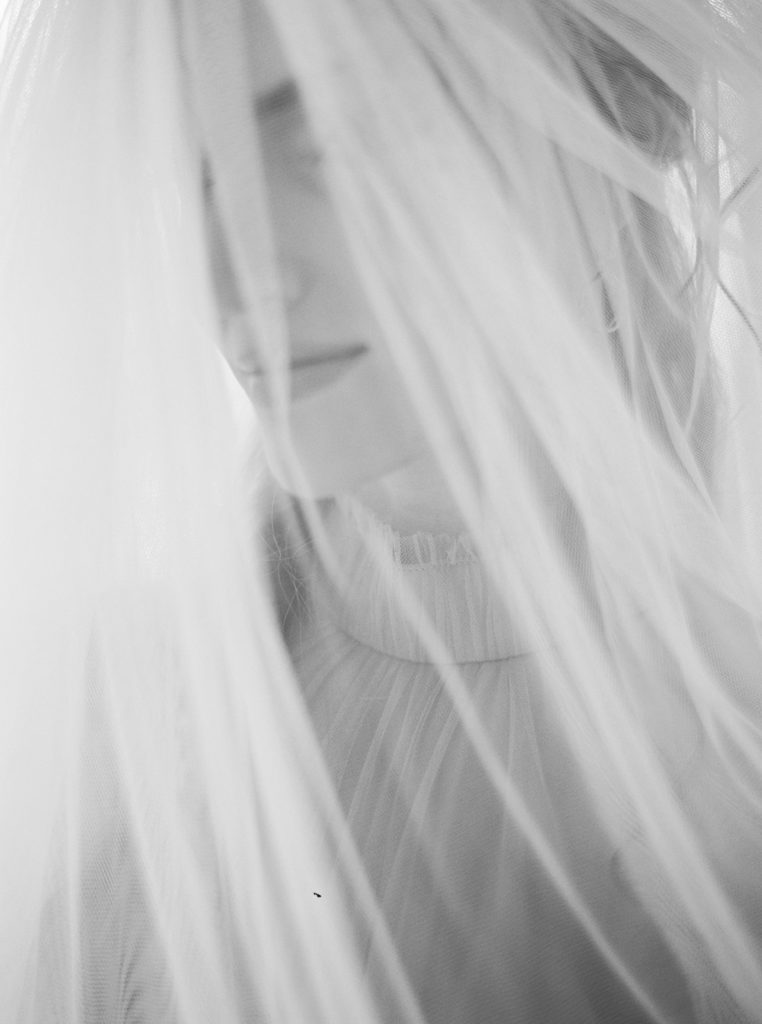 Bride wearing a veil photographed on black and white film