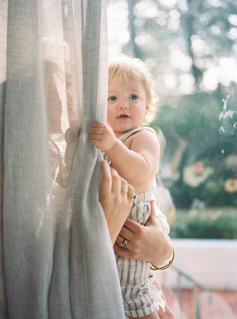 Little boy playing in the curtains at Carley Summers' home