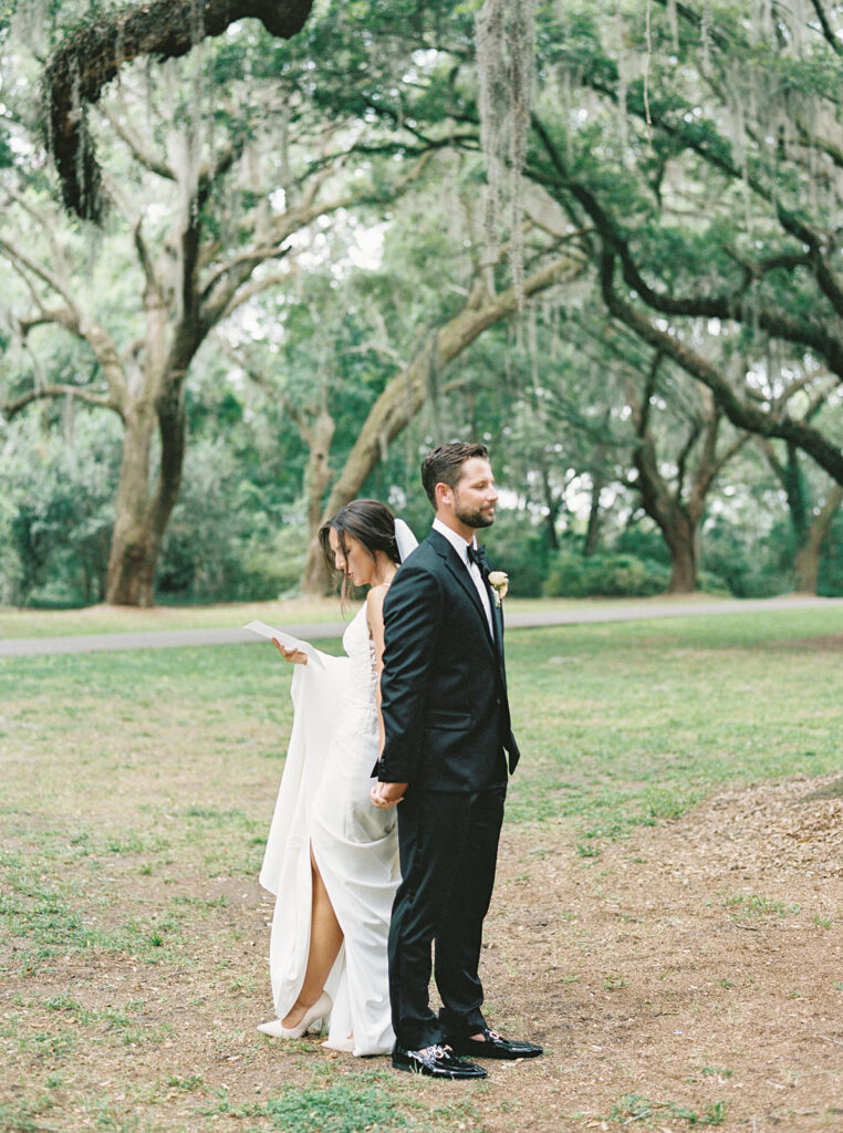 Bride and groom exchanging private vows among mossy trees at their summer wedding in Charleston