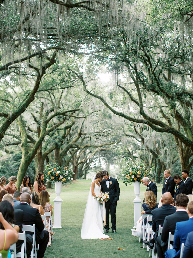 A couple praying at the altar during their summer wedding at Legare Waring House in Charleston
