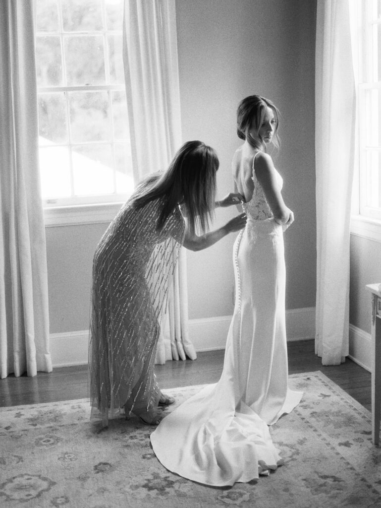 A bride gets ready with her mom at Legare Waring House during her summer wedding in Charleston